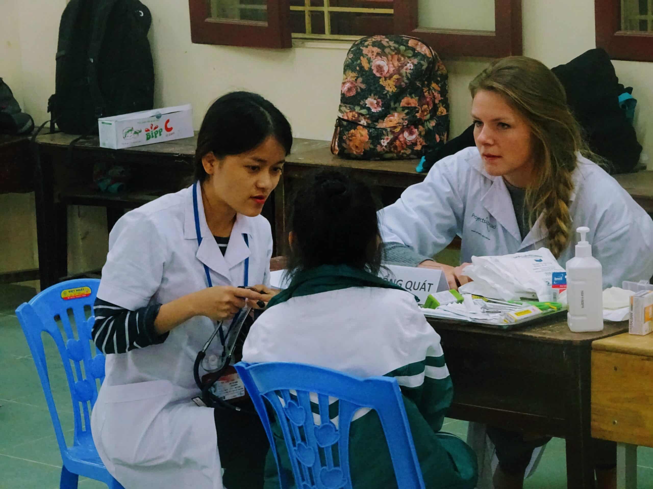 Nursing and medical elective students abroad assist at a health screening in a local Vietnamese school.