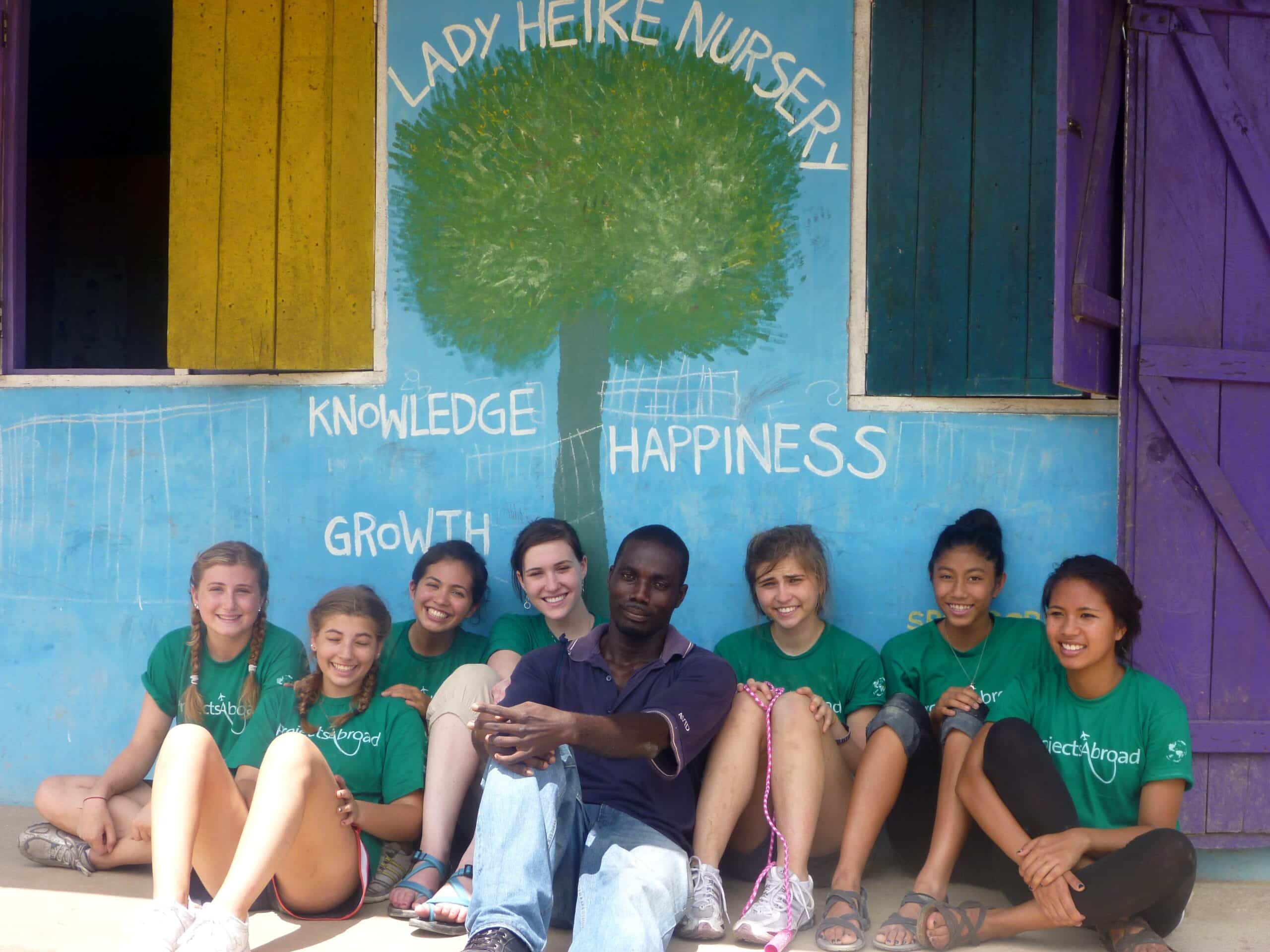 Projects Abroad volunteers sit down for a team photo before continuing their volunteer work with children in Ghana