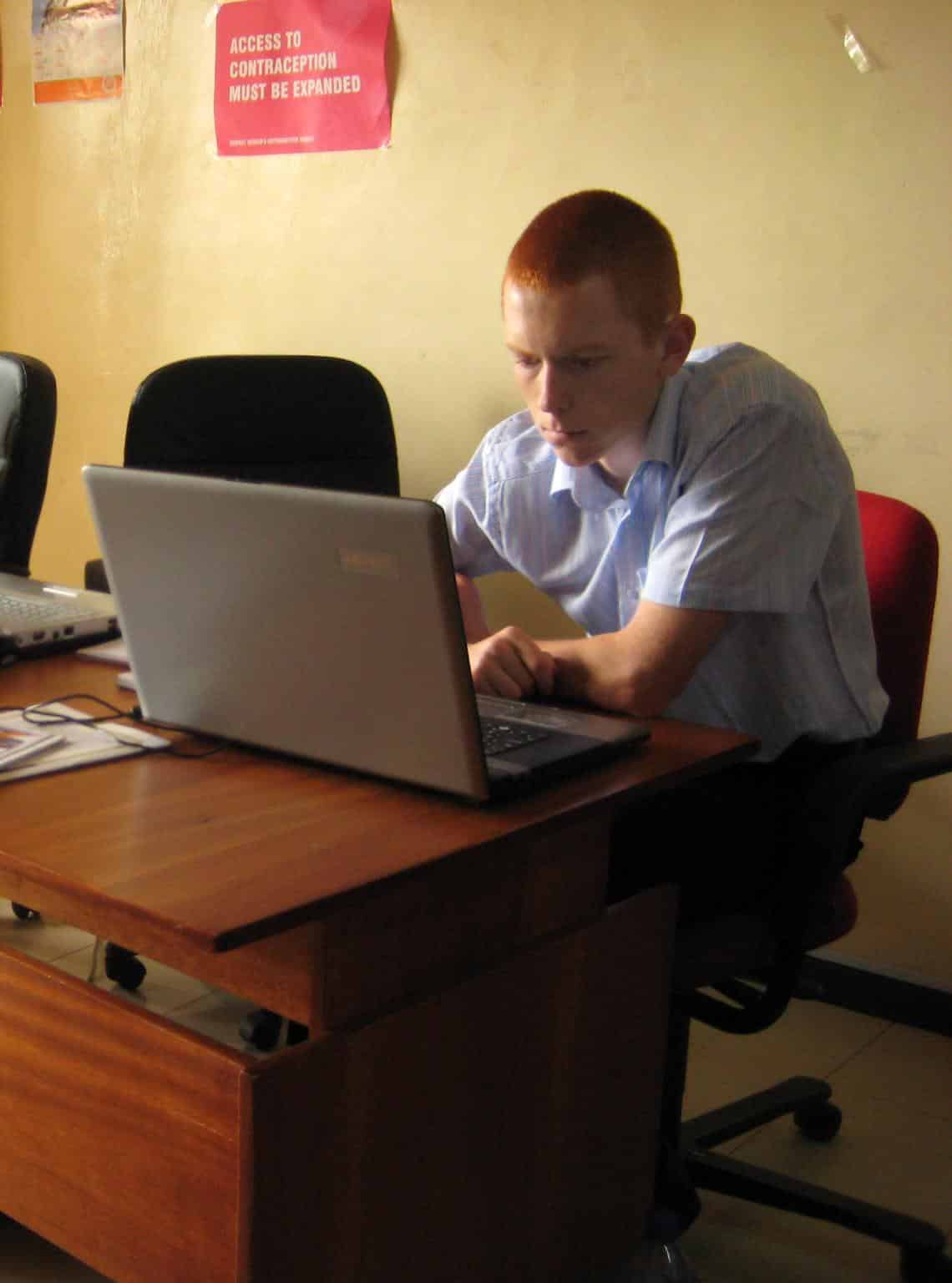 A Projects Abroad volunteer doing an IT teaching internship in Ghana checks the functionality of the computers in a school.