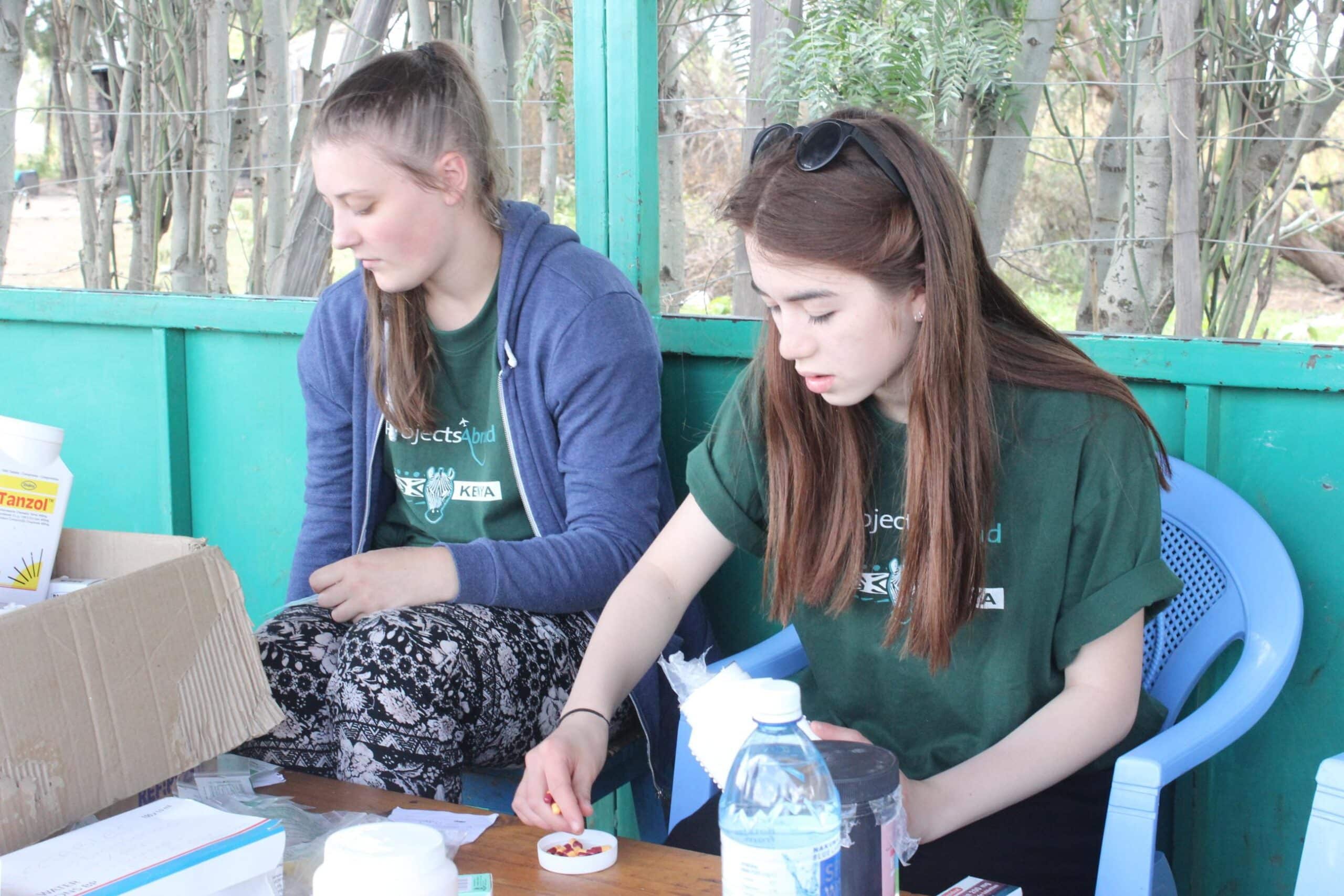 A couple of teenage medical volunteers prepare medicines and equipment for a medical outreach in Kenya while doing their medical internship with Projects Abroad.