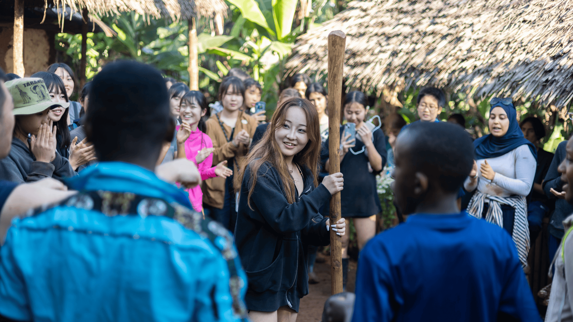 A group of teen travellers join in with a cultural activity in Tanzania