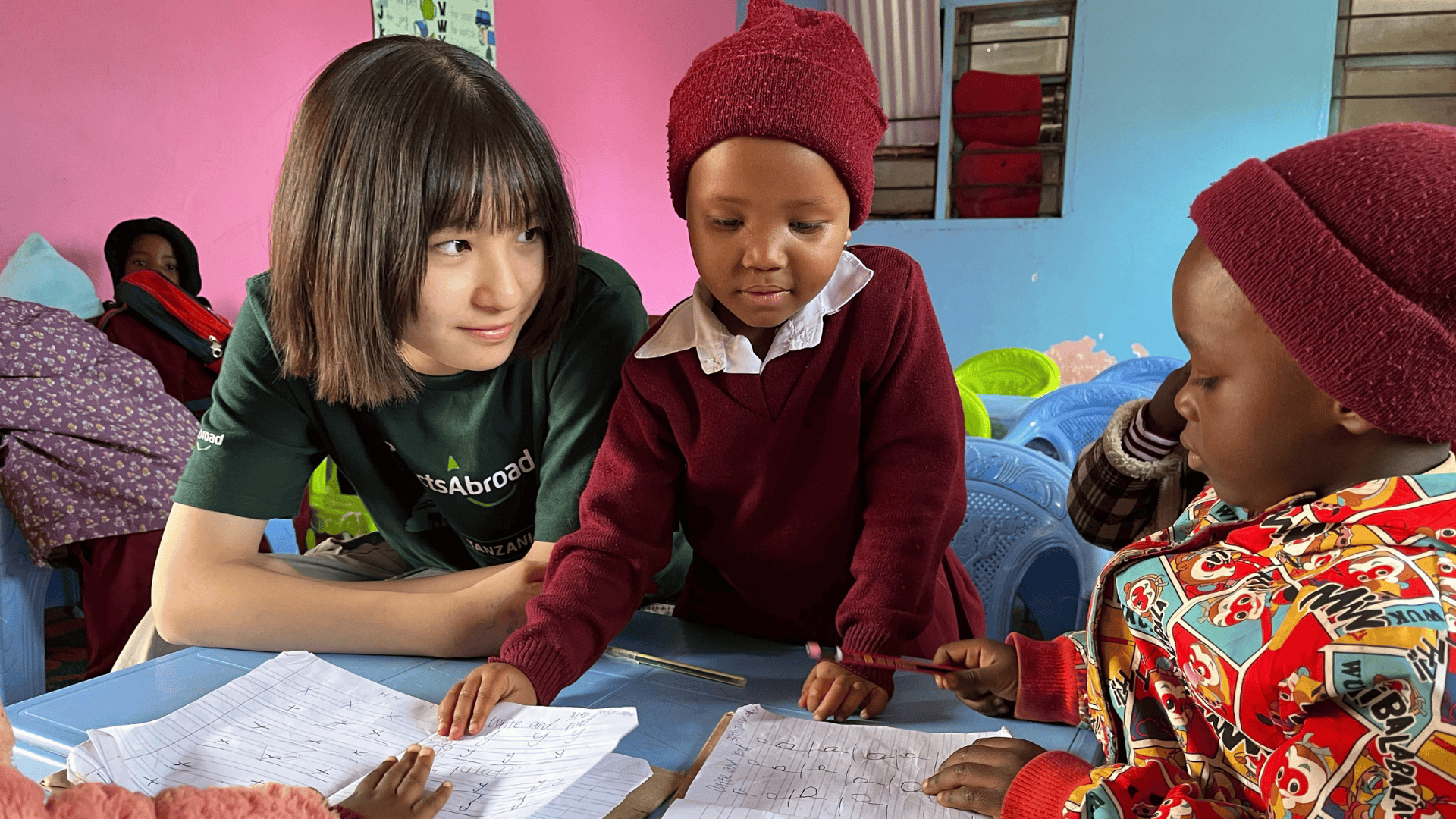 A Japanese volunteer teaches the alphabet to children in Tanzania