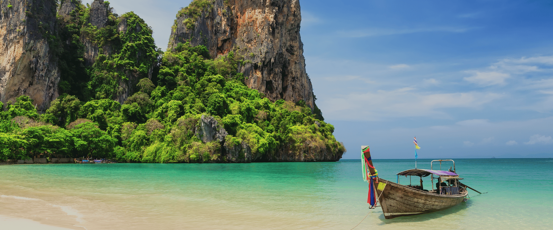 Thai traditional wooden longtail boat and beautiful sand beach